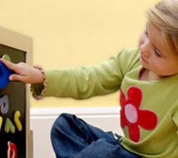 autistic girl touching magnetic letters