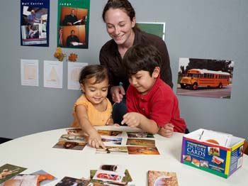 woman-teaching-two-kids-language-with-pictures