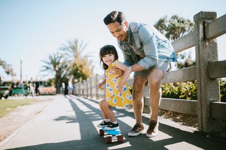 A dad helps his little girl with autism go skateboarding,