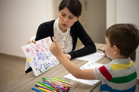 ABA-therapy-therapist-working-with-child-drawing