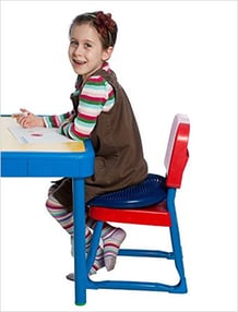 girl-drawing-a-picture-while-sitting-on-a-chair-cushion