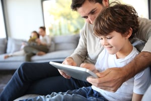 Father and son playing with digital tablet