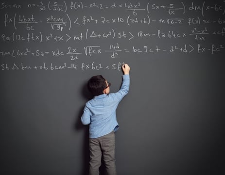 Little child with autism in front of huge blackboard