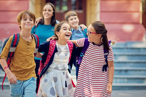 School children with autism walking at the front of the school and make fun together