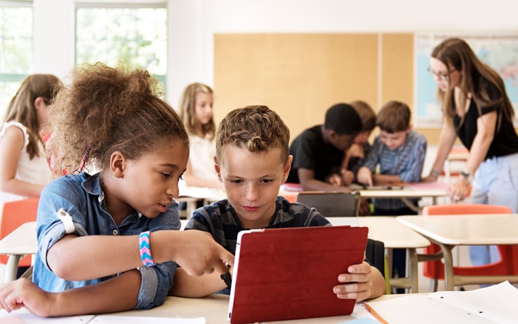 School kids in class using a digital tablet inclusive classroom