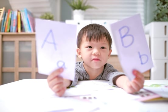boy with autism holding flashcards learning phonological awareness