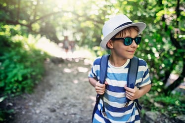 boy with autism on outdoor adventure wearing hat and sunglasses