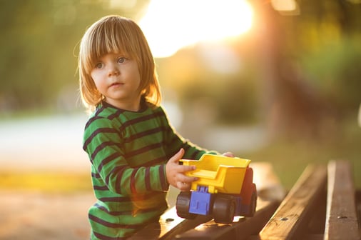 child with autism playing with toy truck