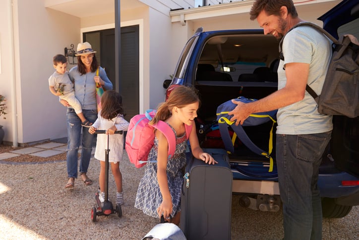 family unpacking car on vacation