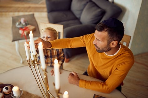 father and son with autism lighting menorah