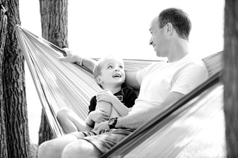 father and autistic son sitting in a hammock