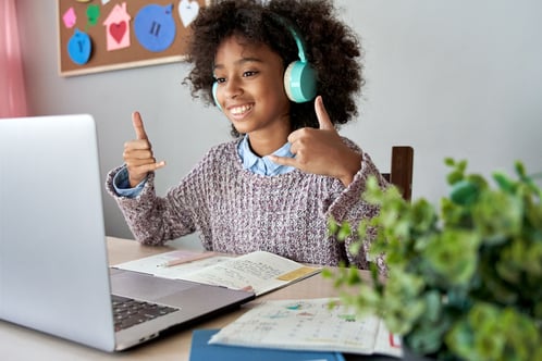 girl with autism learning online class on laptop communicating with teacher by video conference call