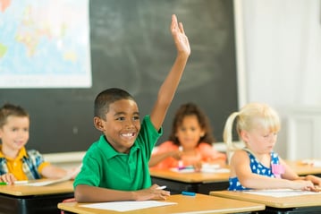happy boy with autism raising hand in class