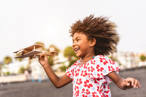 happy girl with autism playing with airplane