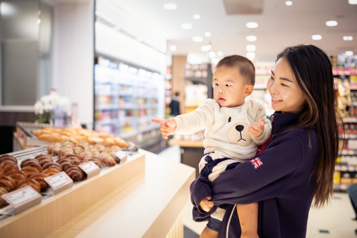 Asian mother carrying her son in a supermarket