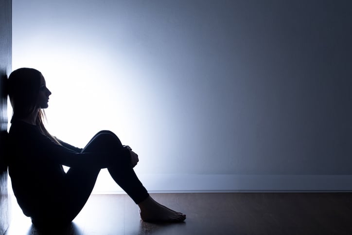 Teenager with autism depression sitting alone in dark room