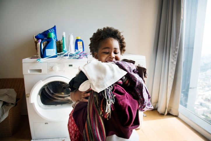 Young boy with autism doing laundry at home