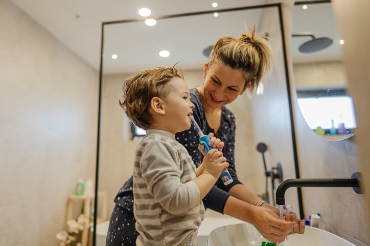 boy with autism brushing teeth with mother