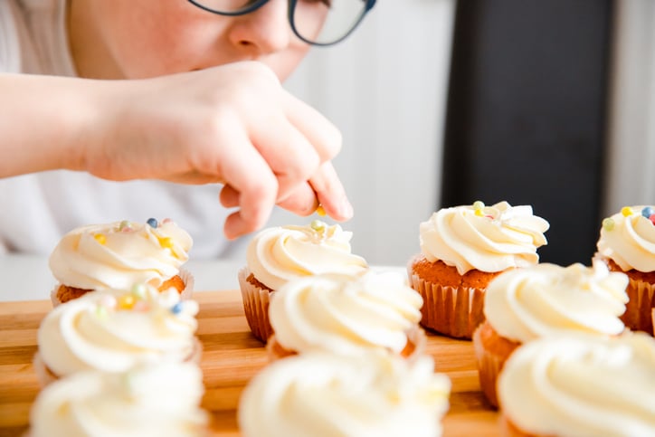 child with autism making cupcakes