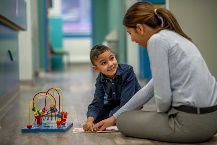 child with autism working with a therapist or teacher