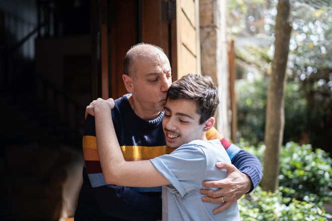 father embracing son with autism