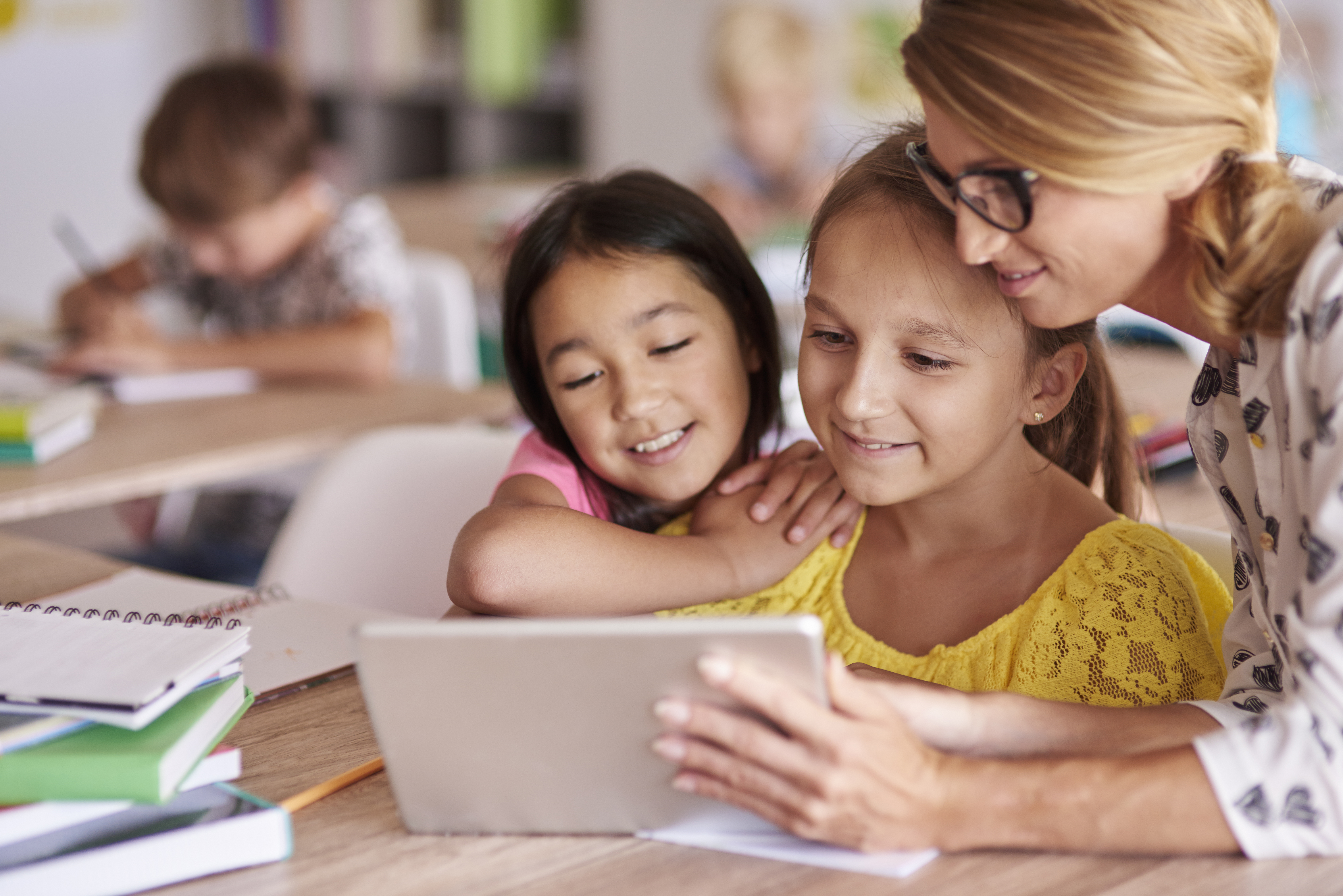 teacher-helping-pupils-with-digital-tablet