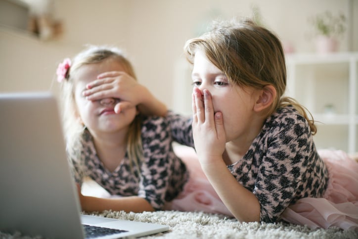 two girls with autism with laptop using senses of touch smell and sight