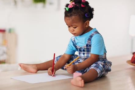 little girl with autism writing with both hands