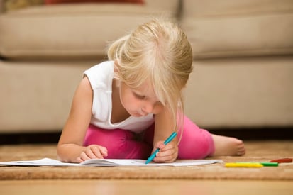little girl with autism writing with left hand