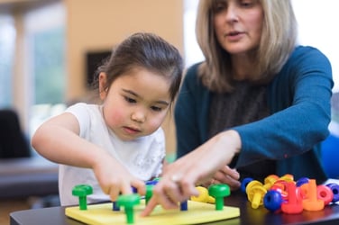 occupational therapist helping girl with autism