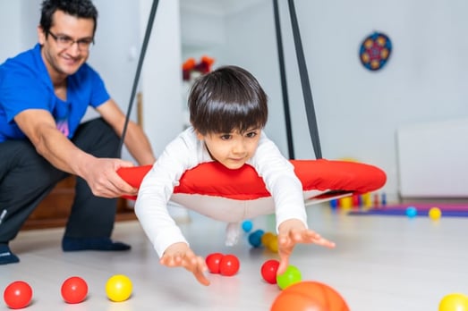 occupational therapist working with boy with autism