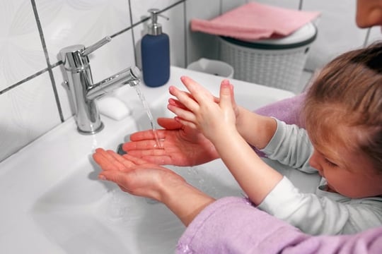 parent teaching daughter with autism how to wash hands