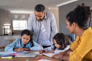 parents helping children with autism with their homework at home