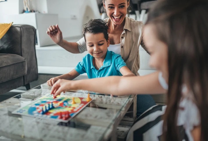 family of child with autism playing cooperative board game